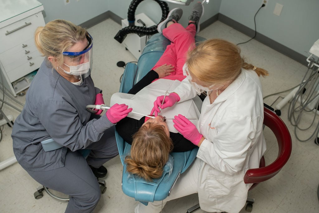 Dental procedure with two professionals assisting. We’re Different Dental Prosthodontics Practice Richmond VA